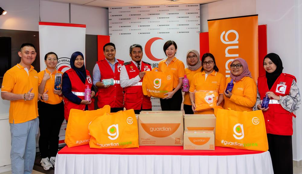 $!MRC secretary-general Hakim Hamzah (5th from left) and Guardian Malaysia senior manager of public relations and events Jennifer Wong (6th from left) at the handover of personal and health care items for flood victims.