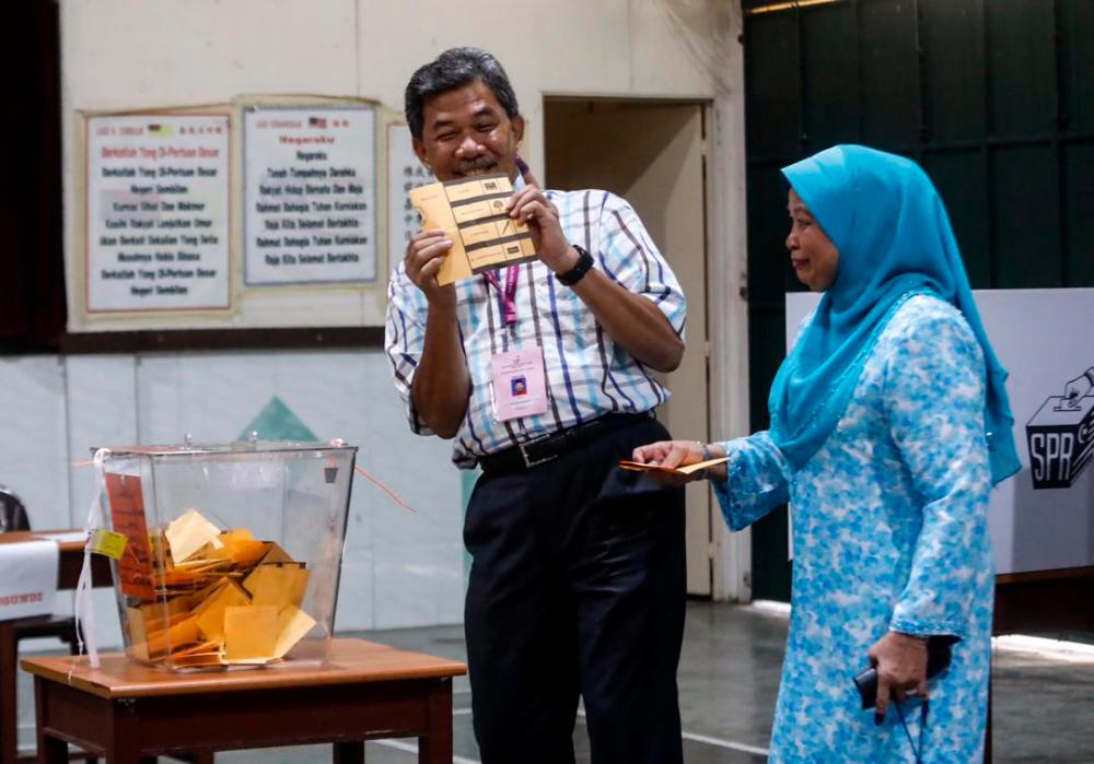 Datuk Seri Mohamad Hassan and his wife Datin Seri Raja Salbiah Tengku Nujumudin cast their votes at SJKC Chung Hua, on April 13, 2019. — Sunpix by Ashraf Shamsul