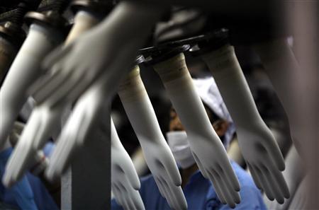 A worker collects rubber gloves at Top Glove’s factory in Klang. REUTERSPIX