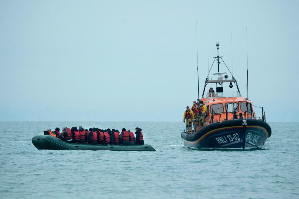 Migrants are helped by RNLI (Royal National Lifeboat Institution) lifeboat before being taken to a beach in Dungeness, on the south-east coast of England/AFPPix