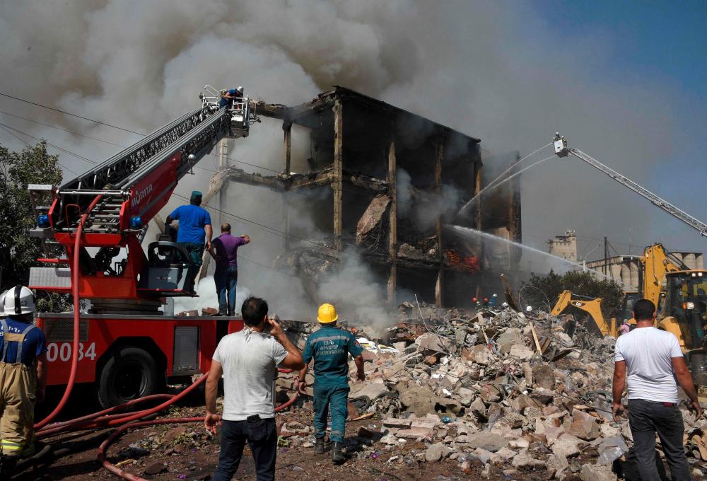 Rescue workerS operate on the site of a retail market in the Armenian capital Yerevan on August 14, 2022, after an explosion sparked a fire, killing one person and injuring 51, according to the emergency situations ministry. AFPPIX