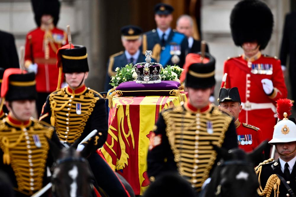 The coffin of Queen Elizabeth II, adorned with a Royal Standard and the Imperial State Crown and pulled by a Gun Carriage of The King's Troop Royal Horse Artillery, is pictured during a procession from Buckingham Palace to the Palace of Westminster, in London/AFPPix