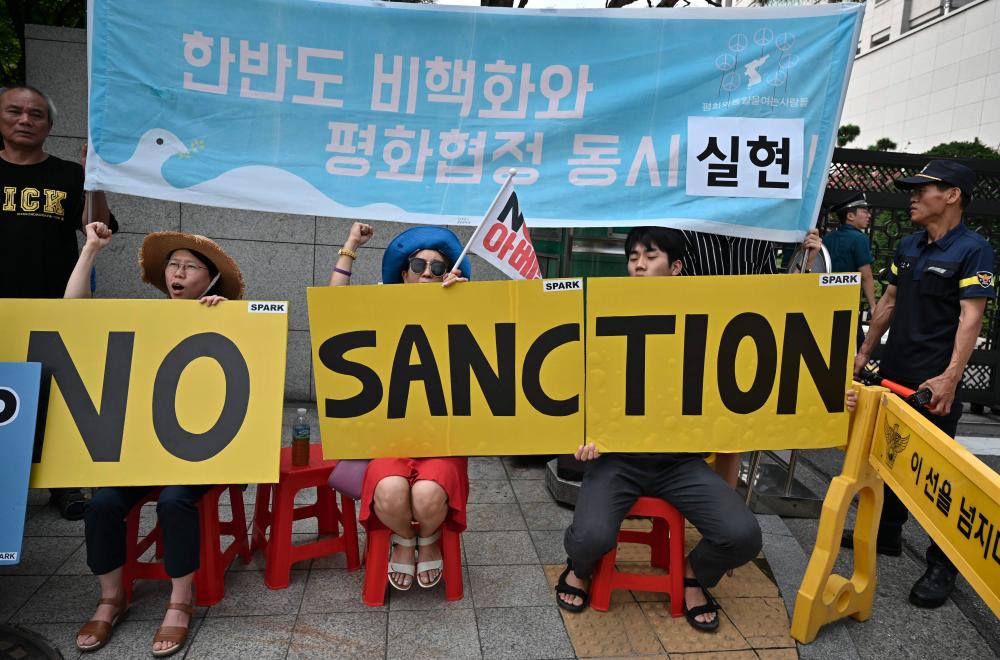 Anti-war activists hold placards as US Special Representative for North Korea Stephen Biegun (not pictured) arrives at the Foreign Ministry in Seoul on August 21, 2019. - AFP