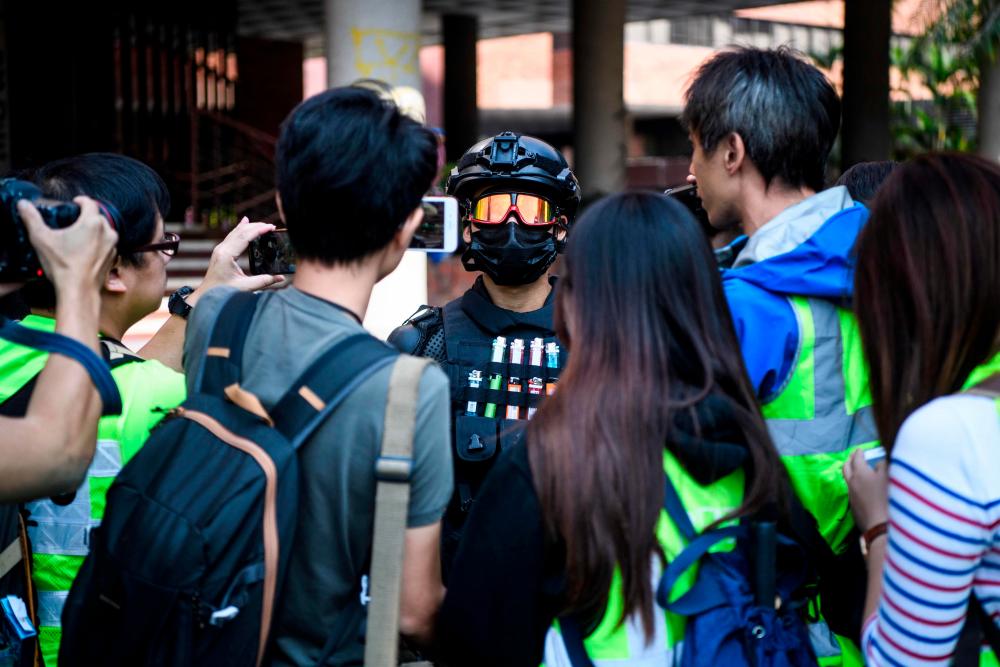 A male protester (C), who gave his age as 16, speaks to the media at the campus of the Hong Kong Polytechnic University in the Hung Hom district of Hong Kong on November 20, 2019. - AFP