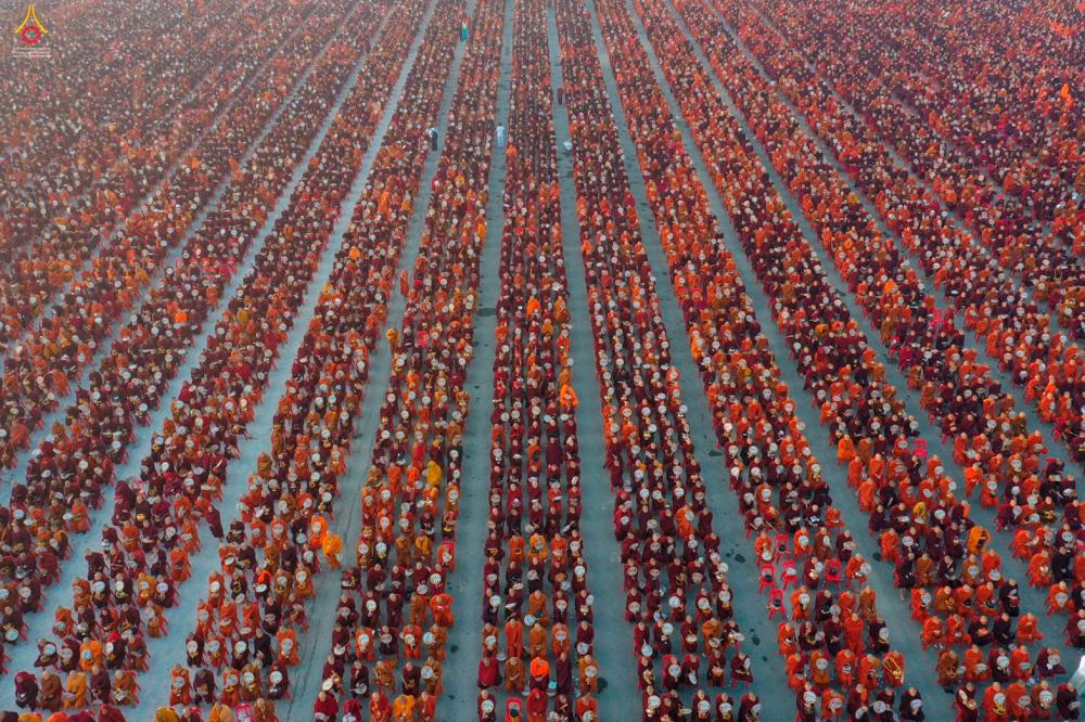 A handout photo taken on December 8, 2019 and released by Dhammakaya Fondation shows monks lining up for alms during the alms-giving ceremony to 30,000 monks organize by the region government of Mandalay affiliated with Dhammakaya Foundation at Chanmyathazi Airport in Mandalay. - AFP