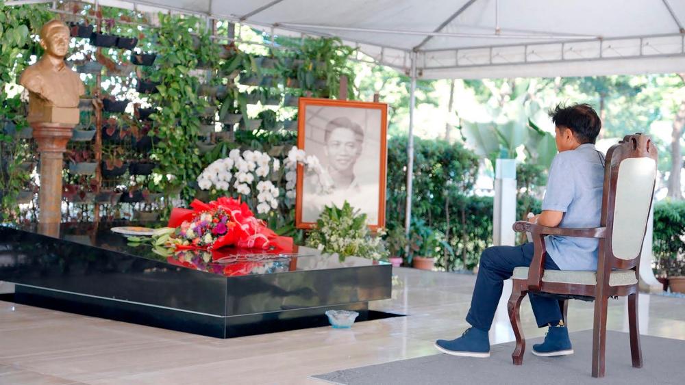 This handout photo taken on May 10, 2022 and received on May 11 from the Bongbong Marcos (BBM) media bureau shows presidential candidate Ferdinand Marcos Jr visiting the grave of his father, the late president Ferdinand Marcos at the Heroes’ Cemetery in Taguig City, suburban Manila. AFPPIX