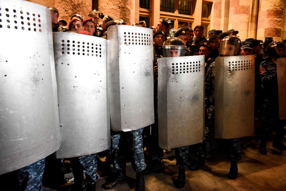 Armenian police officers guard the entrance to the government building during clashes with protesters calling on Armenian Prime Minister Nikol Pashinyan to resign in central Yerevan//AFPix