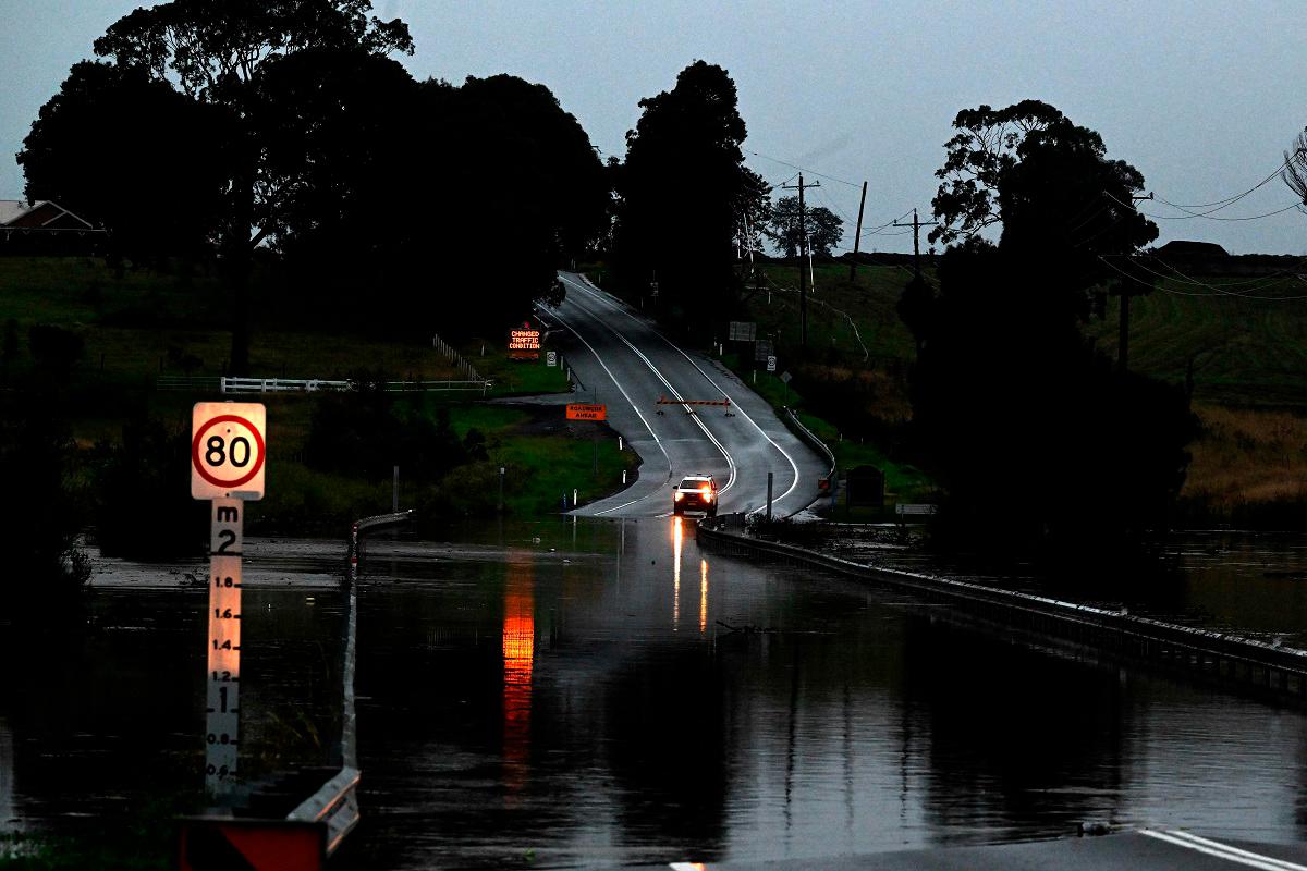 A road is seen flooded from the over flowing Wallis Creek in Gillieston Heights near New South Wales town of Maitland on May 22, 2025. Record floods cut a destructive path through eastern Australia on May 23, caking houses in silt, washing out roads and separating 50,000 people from help. - Saeed KHAN / AFP