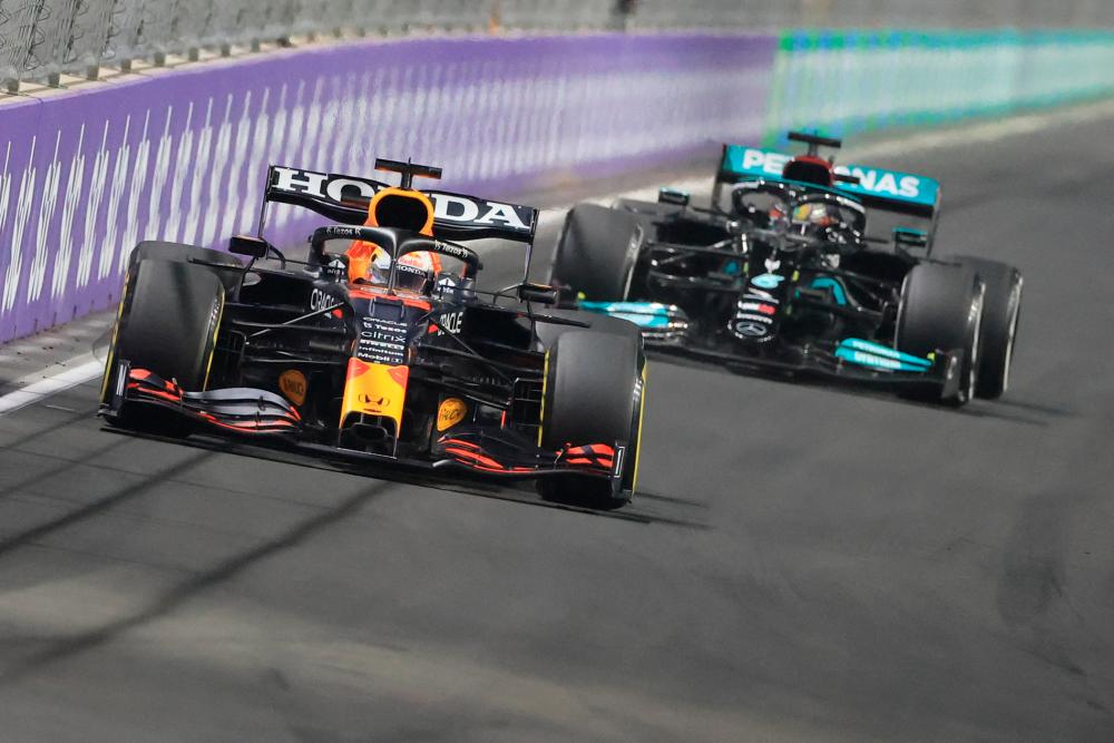 TOPSHOT - Red Bull's Dutch driver Max Verstappen (L) and Mercedes' British driver Lewis Hamilton compete in the Formula One Saudi Arabian Grand Prix at the Jeddah Corniche Circuit in Jeddah on December 5, 2021. AFPpix