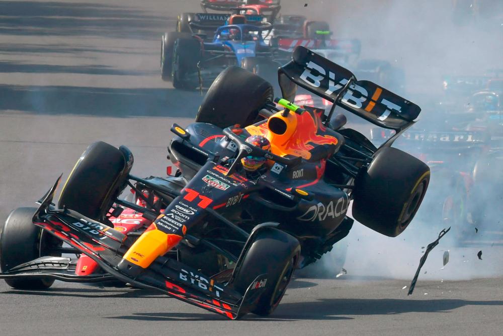 Red Bull Racing’s Mexican driver Sergio Perez (R) crashes with Ferrari’s Monegasque driver Charles Leclerc at the start of the Formula One Mexico Grand Prix at the Hermanos Rodriguez racetrack in Mexico City on October 29, 2023.//AFPPIX