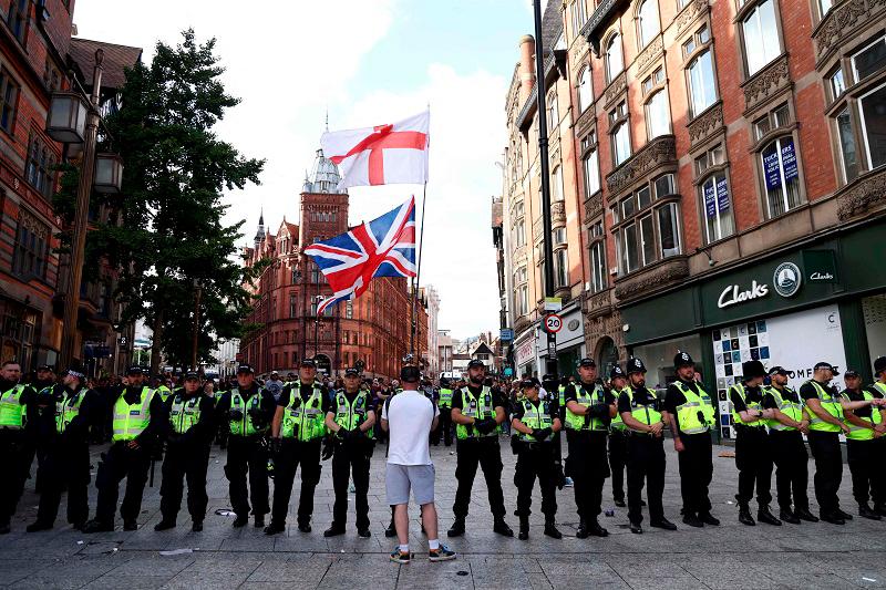 Police officers form a line in front of counter protesters in Nottingham, central England, on August 3, 2024 against the ‘Enough is Enough’ demonstration held in reaction to the fatal stabbings in Southport on July 29. UK police prepared for planned far-right protests and other demonstrations this weekend, after two nights of unrest in several English towns and cities following a mass stabbing that killed three young girls. - (Photo by Darren Staples / AFP)