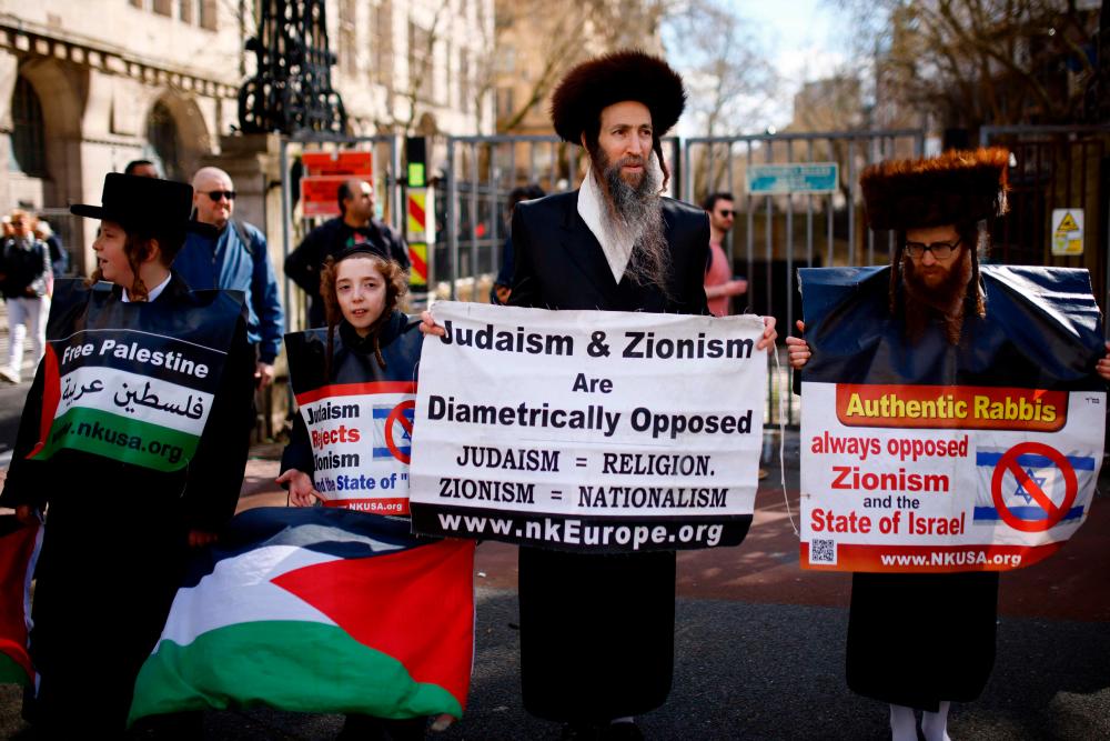 Members of the Ultra-Orthodox Jewish community hold placards as they join pro-Palestinian activists and supporters for a protest in central London, calling for a ceasefire in the Israel/Hamas conflict. - AFPpix