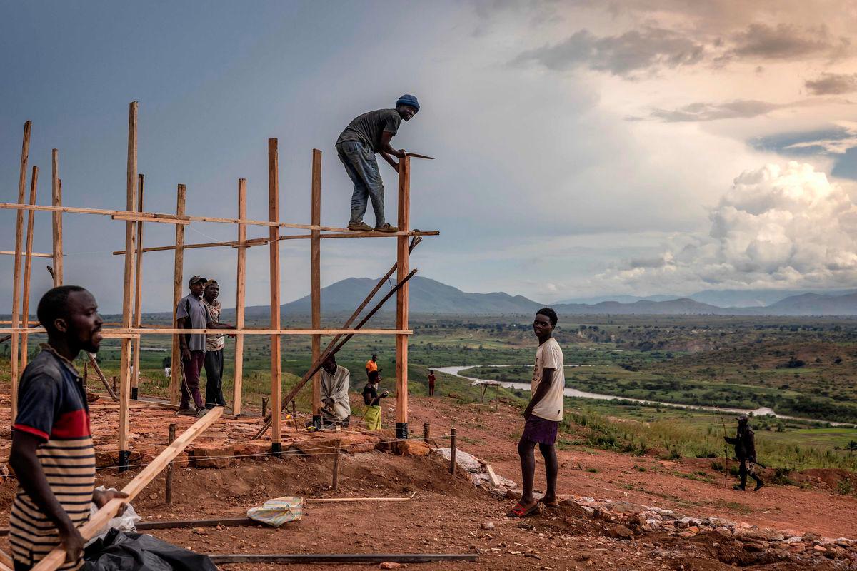 Internally displaced people, forced from their homes by rising waters of Lake Tanganyika, build a new structure at the Gateri IDP camp in Gateri, on May 5, 2025. - AFPPIX