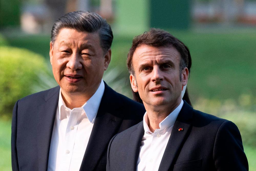 Chinese President Xi Jinping (L) and French President Emmanuel Macron (R) visit the garden of the residence of the Governor of Guangdong, on April 7, 2023, where Chinese President XI Jinping’s father, XI Zhongxun lived. AFPPIX