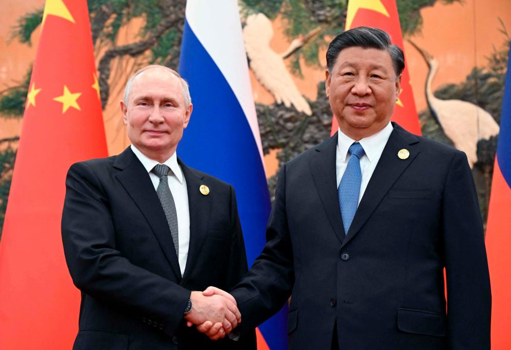 This pool photograph distributed by Russian state owned agency Sputnik shows Russia’s President Vladimir Putin and Chinese President Xi Jinping shaking hands during a meeting in Beijing on October 18, 2023. AFPPIX