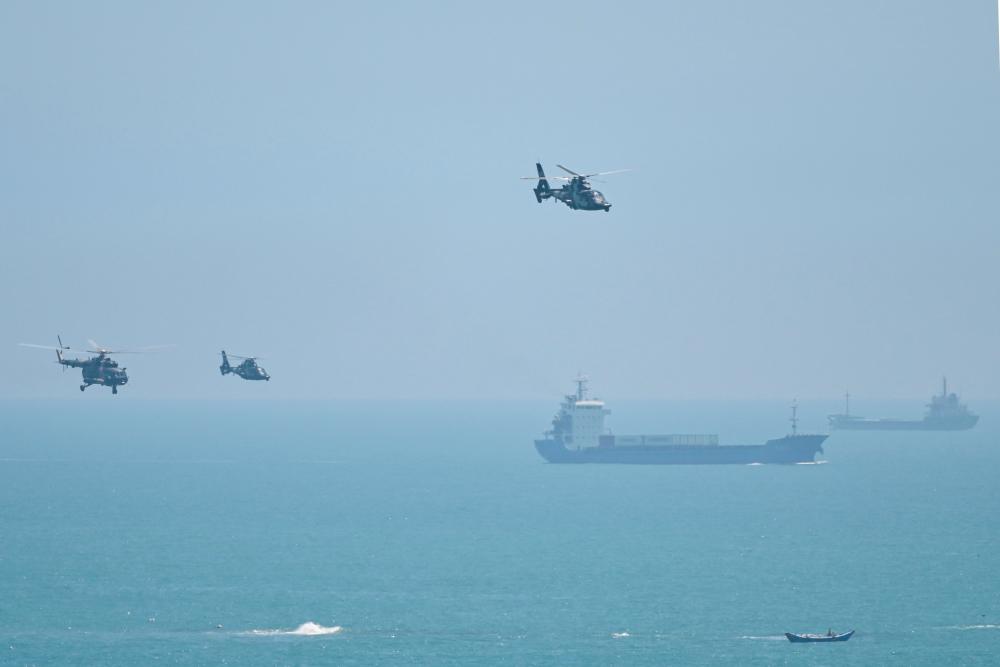 Chinese military helicopters fly past Pingtan island, one of mainland China's closest point from Taiwan, in Fujian province on August 4, 2022, ahead of massive military drills off Taiwan following US House Speaker Nancy Pelosi's visit to the self-ruled island. - AFPPIX