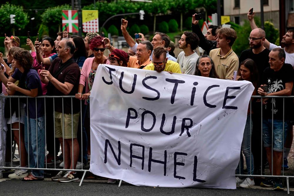 Spectator deploy a banner which reads “Justice for Nahel” along the race route at the start of the 1st stage of the 110th edition of the Tour de France cycling race, 182 km departing and finishing in Bilbao, in northern Spain, on July 1, 2023. AFPPIX