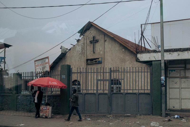 A man walks past a church that was hit by an artillery shell following clashes in Goma on January 30, 2025. DR Congo's president has vowed a vigorous military response against Rwandan-backed fighters who advanced further in the mineral-rich east of the country after seizing most of the region's main city, where some residents tentatively emerged on January 30, 2025. The M23's capture of most of Goma, the capital of North Kivu province, is a dramatic escalation of a decade-long conlfict that has seen it seize swathes of eastern Democratic Republic of Congo. - ALEXIS HUGUET / AFP