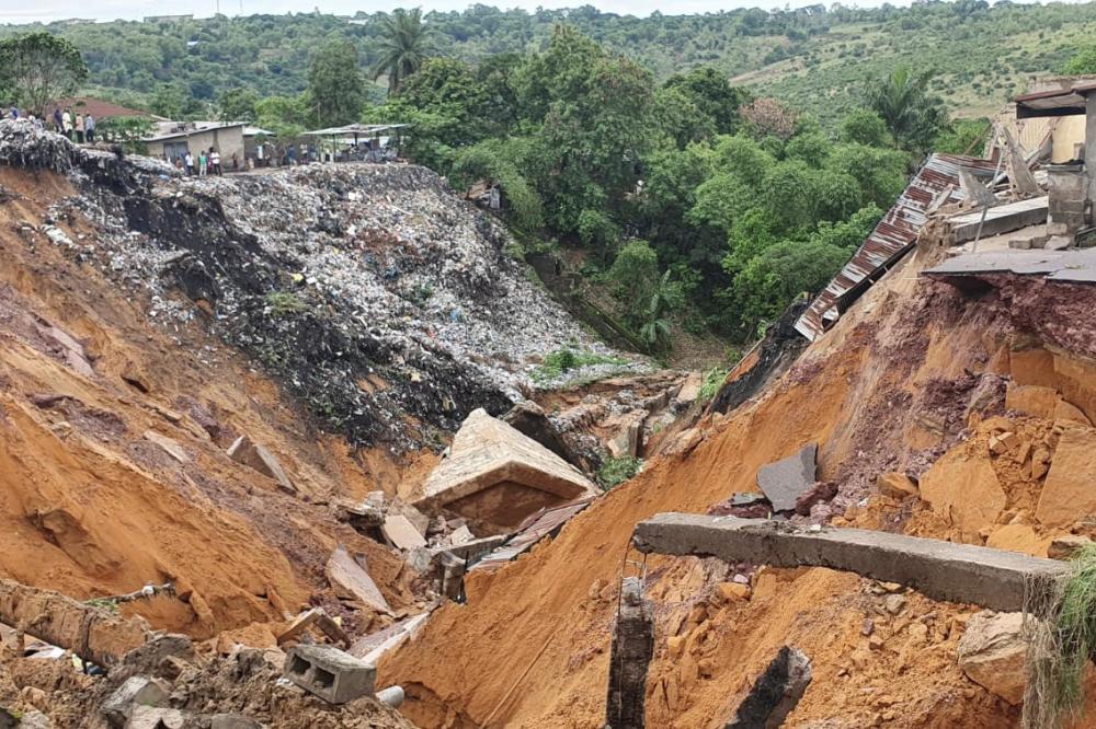 A road surface swept away by a landslide caused by torrential overnight rains is photographed in the Lemba district of Kinshasa, on Nov 26. — AFP