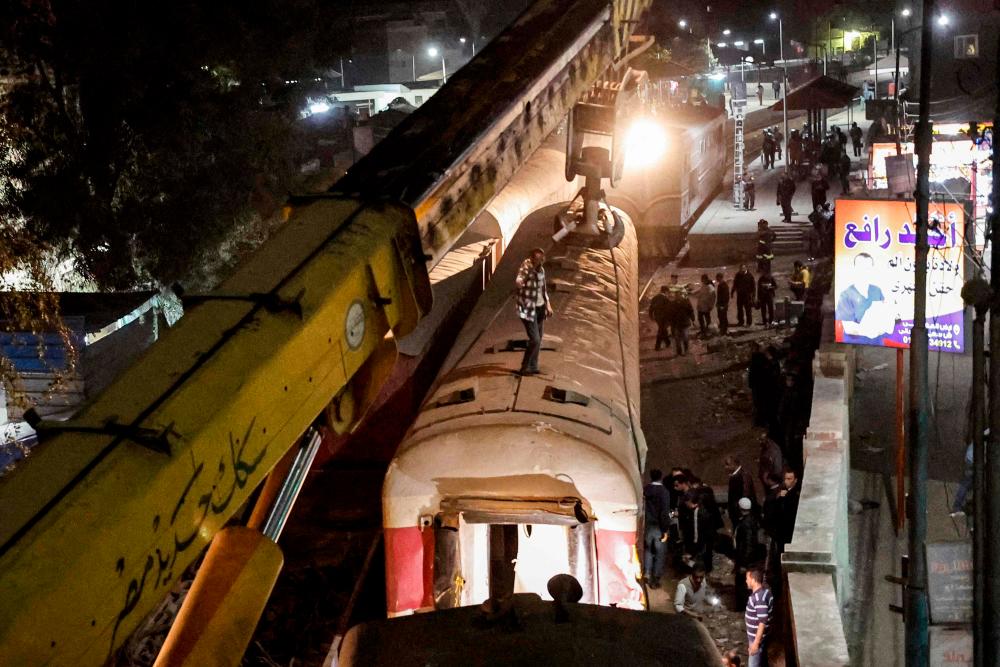 A crane is deployed to lift a derailed train at the scene of a railroad accident in the city of Qalyub in Qalyub province, in Egypt’s Nile delta region north of the capital on March 7, 2023. AFPPIX