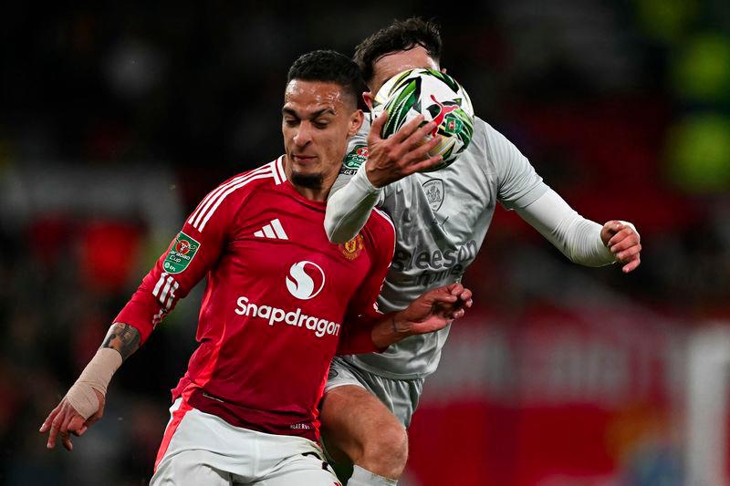 Barnsley's Irish defender #07 Corey O'Keeffe vies with Manchester United's Brazilian midfielder #21 Antony before hand-balling the ball in the lead up to Manchester United's fifth goal, during the English League Cup third round football match between Manchester United and Barnsley at Old Trafford in Manchester, north west England, on September 17, 2024. - AFPPIX