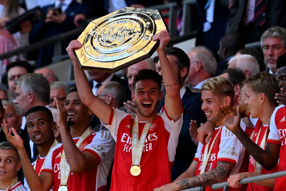 TOPSHOT - Arsenal's English midfielder Declan Rice lifts the trophy after Arsenal win the shoot-out after the English FA Community Shield football match between Arsenal and Manchester City at Wembley Stadium, in London, August 6, 2023. - AFPPIX