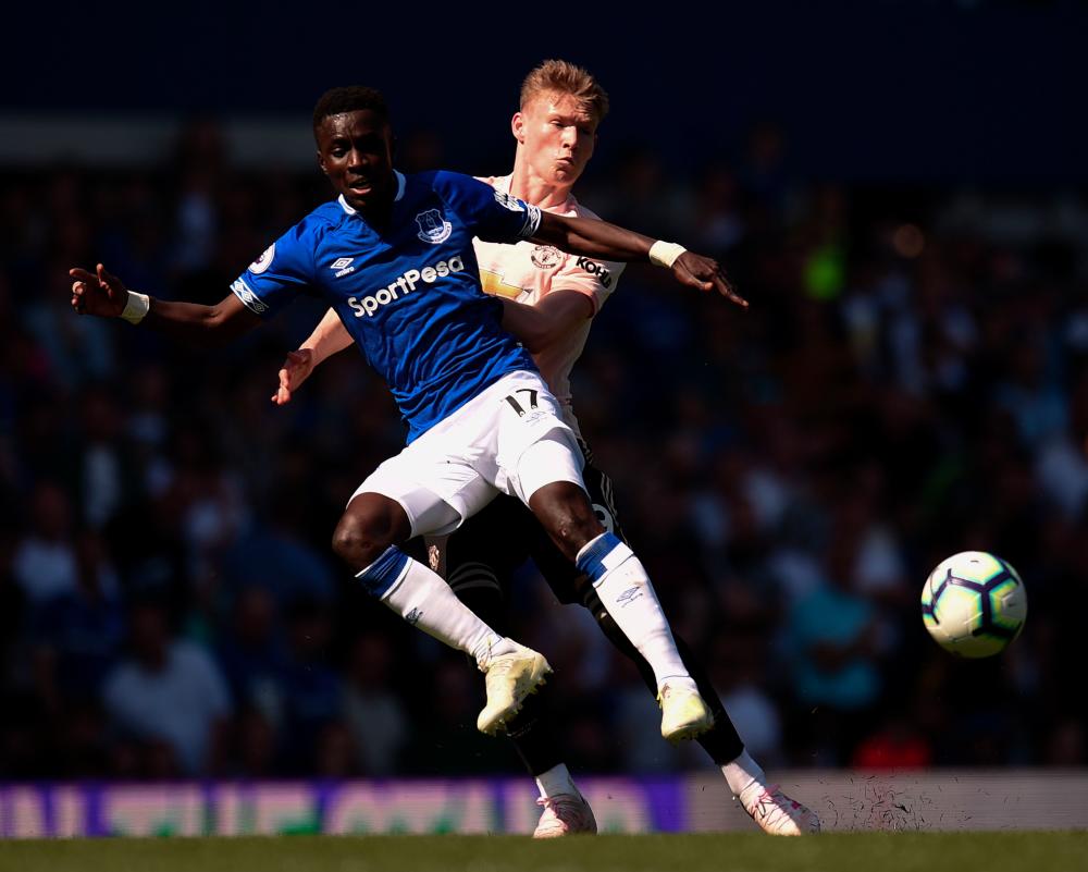 Everton's Senegalese midfielder Idrissa Gueye (L) is pressured by Manchester United's English midfielder Scott McTominay (R) during the English Premier League football match between Everton and Manchester United at Goodison Park in Liverpool, north west England on April 21, 2019. — AFP