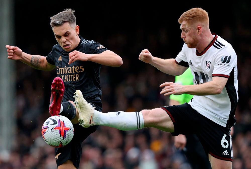 Fulham's English midfielder Harrison Reed (R) vies with Arsenal's Belgian midfielder Leandro Trossard during the English Premier League football match between Fulham and Arsenal at Craven Cottage in London on March 12, 2023. AFPPIX