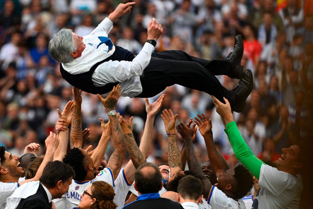Real Madrid's players carry Real Madrid's Italian coach Carlo Ancelotti at the end of the Spanish League football match between Real Madrid CF and RCD Espanyol at the Santiago Bernabeu stadium in Madrid on April 30, 2022. AFPPIX