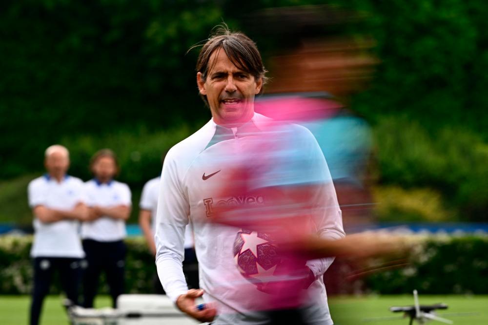 A player runs past Inter Milan’s Italian head coach Simone Inzaghi during a training session on June 5, 2023 at the club’s training ground in Appiano Gentile, north of Milan, as part of a Media Day, five days ahead of Inter Milan’s UEFA Champions League final against Manchester City. AFPPIX