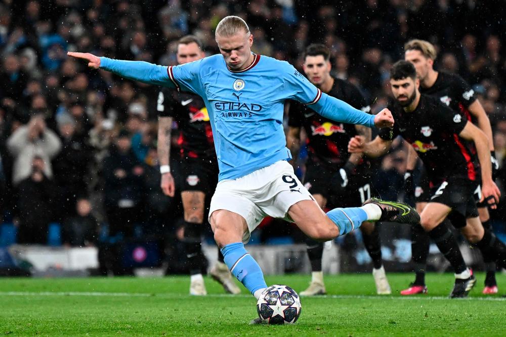 Manchester City’s Norwegian striker Erling Haaland shoots from the penalty spot to score the team’s opening goal during the UEFA Champions League round of 16 second-leg football match between Manchester City and RB Leipzig at the Etihad Stadium in Manchester, north west England, on March 14, 2023. AFPPIX