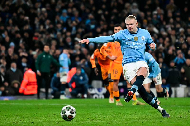 Manchester City's Norwegian striker #09 Erling Haaland shoots a penalty kick and scores his team second goal during the UEFA Champions League football match between Manchester City and Real Madrid at the Etihad Stadium in Manchester, north west England, on February 11, 2025. - AFPPIX