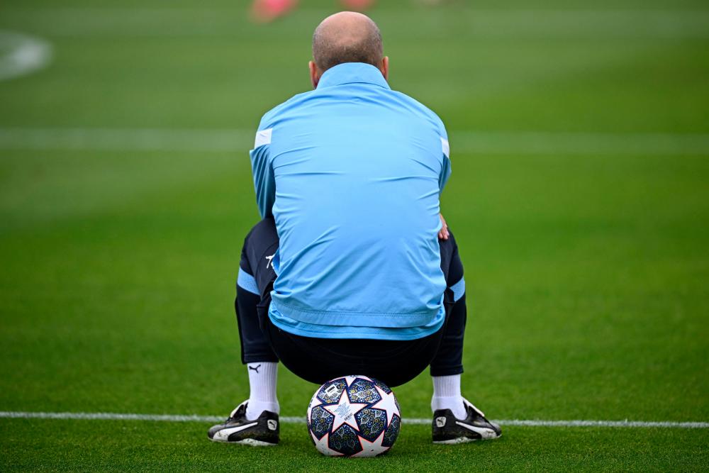 Manchester City's Spanish manager Pep Guardiola sits on a ball as he takes part in a team training session at Manchester City training ground in Manchester, north-west England. AFPPIX