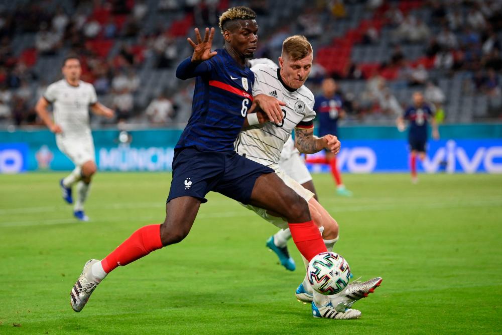 France’s midfielder Paul Pogba (left) vies for the ball with Germany’s midfielder Toni Kroos during the UEFA EURO 2020 Group F match at the Allianz Arena in Munich today morning. – AFPPIX
