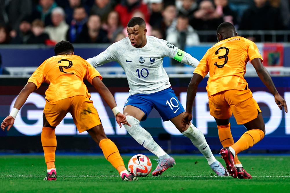 France’s forward Kylian Mbappe (C) fights for the ball with Netherlands’ midfielder Jurrien Timber (L) and Netherlands’ defender Lutsharel Geertruida (R) during the UEFA Euro 2024 qualification football match between France and Netherlands at the Stade de France in Saint-Denis, north of Paris, on March 24, 2023. AFPPIX