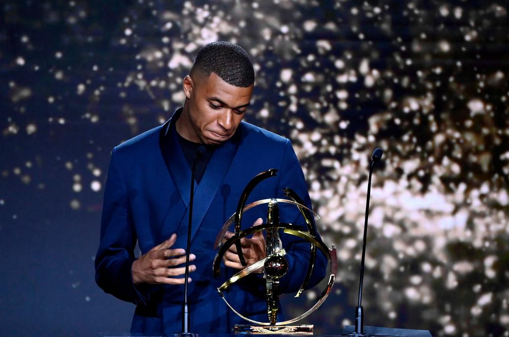 TOPSHOT - Paris Saint-Germain’s French forward Kylian MBappe receives the Best Ligue 1 Player award during the TV show on May 15, 2022 in Paris, as part of the 30th edition of the UNFP (French National Professional Football players Union) trophy ceremony. AFPPIX