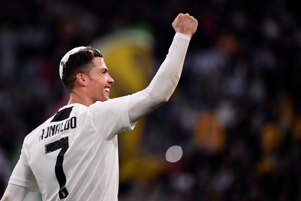 Juventus' Portuguese forward Cristiano Ronaldo acknowledges fans and celebrates after Juventus secured its 8th consecutive Italian 2018/19 Scudetto Serie A championships, after winning the Italian Serie A football match Juventus vs Fiorentina on April 20, 2019 at the Juventus stadium in Turin. — AFP