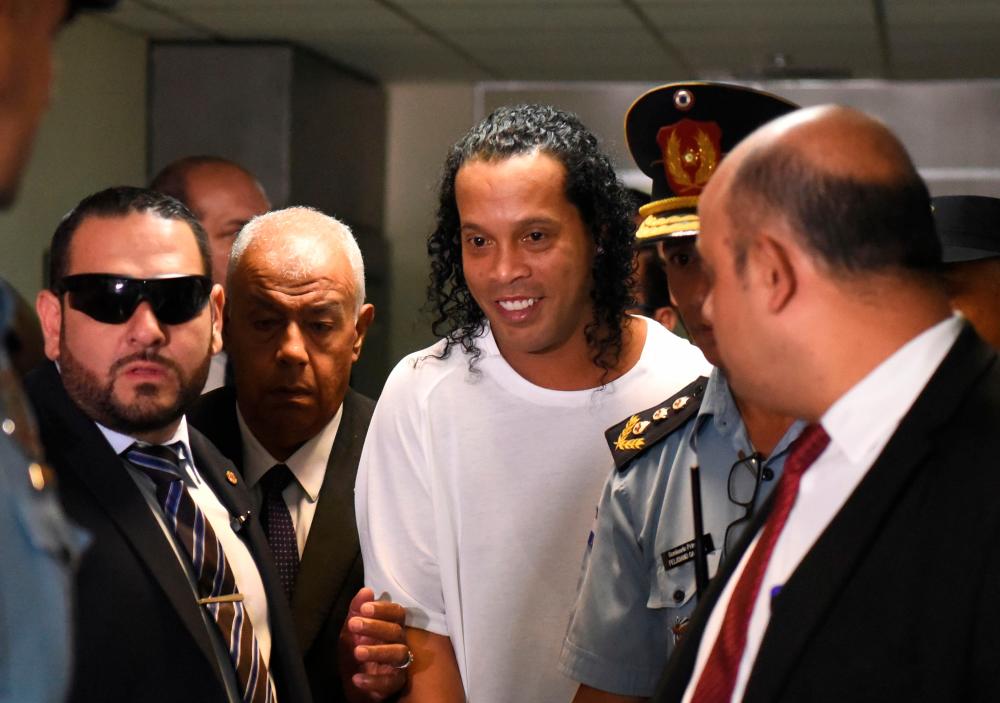Brazilian retired football player Ronaldinho (C) arrives at Asuncion’s Justice Palace to testify about his irregular entry to the country, in Asuncion, on Mar 6, 2020. — AFP