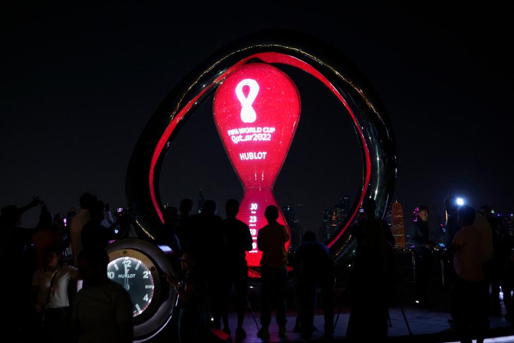 Visitors take pictures of the Qatar 2022 FIFA World Cup countdown clock as it marks thirty days for the start of the international football competition, in the Qatari capital Doha on October 20, 2022. AFPPIX
