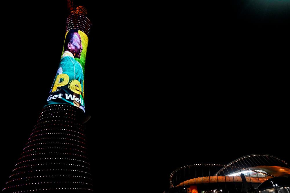 A picture taken on December 3, 2022, in Doha, during the Qatar 2022 World Cup football tournament, shows the Torch tower of Doha also knows as the Aspire Tower, lighten up by a screen depicting Brazilian star Pele and reading a message in support to the former Brazilian football player who is being treated for a “respiratory infection” at the hospital in Sao Paulo/AFPPix