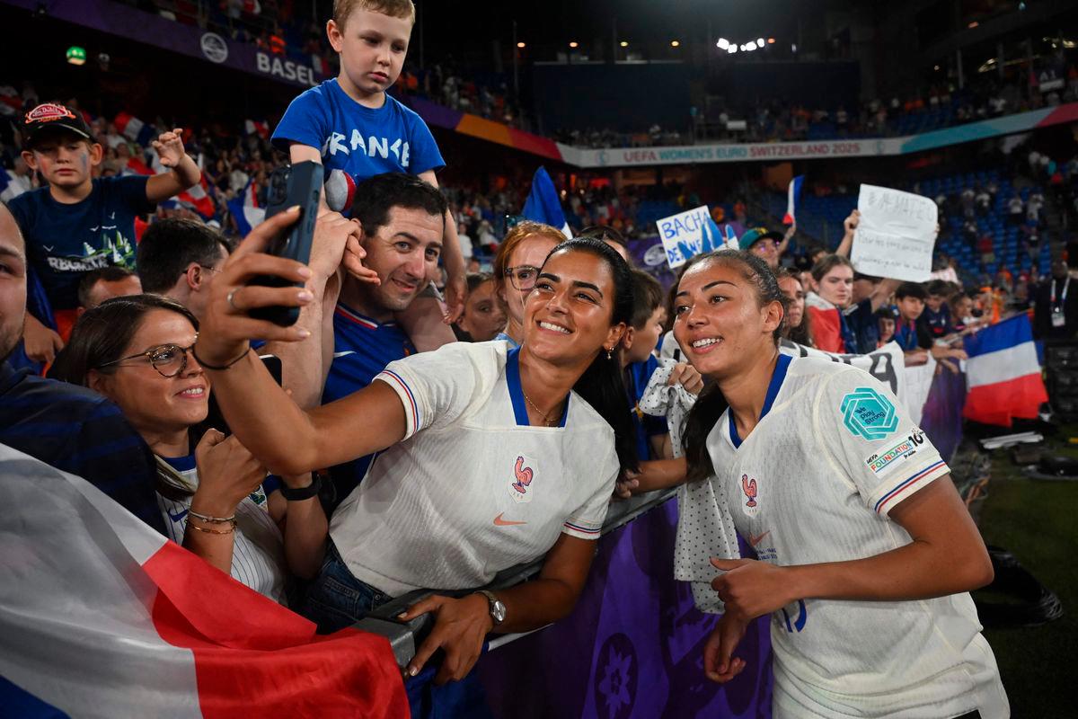France’s defender #13 Selma Bacha (R) poses for a selfie as she celebrates her team’s victory with fans at the end of the UEFA Women’s Euro 2025 Group D football match between The Netherlands and France at the St. Jakob-Park Stadium in Basel, on July 13, 2025. Photo by Miguel MEDINA / AFP