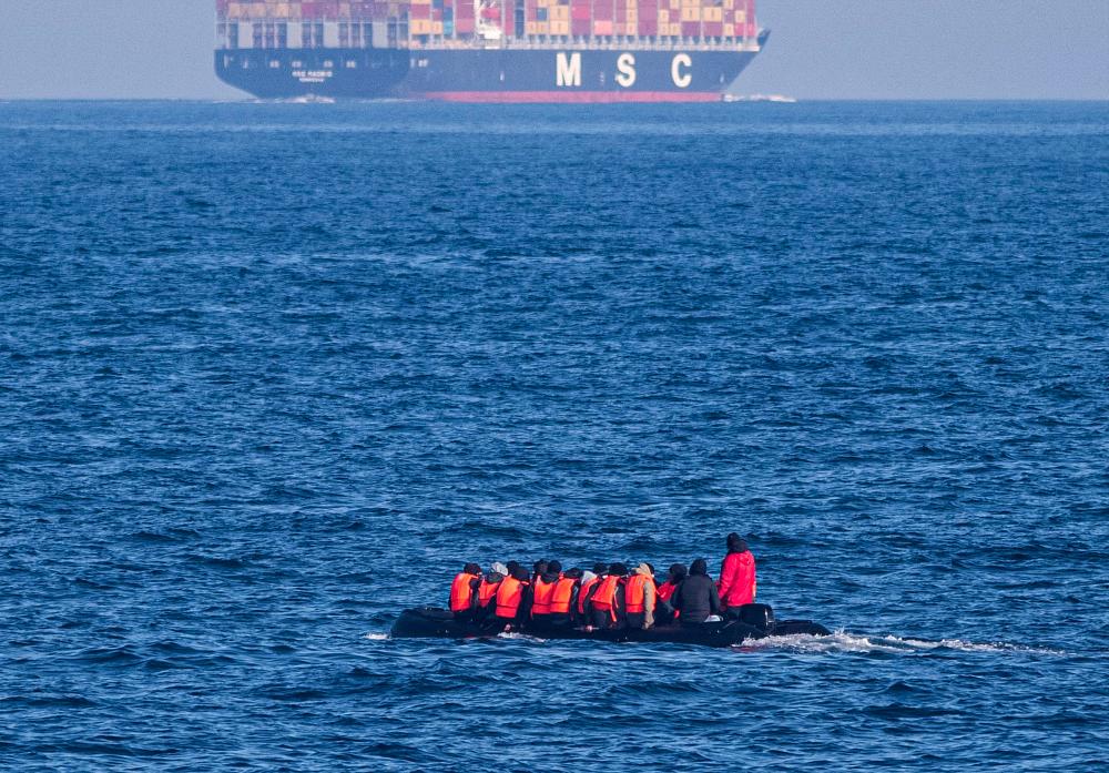 Migrants wearing life jackets sit in a dinghy as they illegally cross the English Channel from France to Britain on March 15, 2022. - AFPPIX