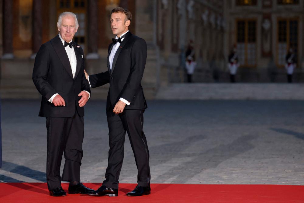 Britain King Charles III (L) is welcomed by French President Emmanuel Macron as they arrive to attend a state banquet at the Palace of Versailles, west of Paris, on September 20, 2023, on the first day of a British royal state visit to France. AFPPIX