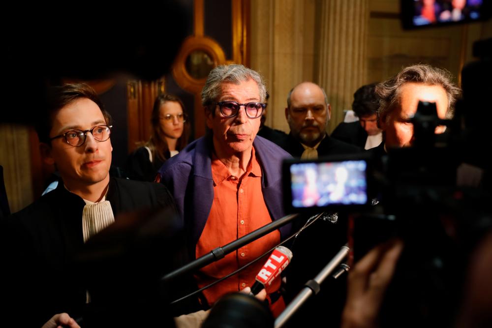 Patrick Balkany (C) and his lawyer Romain Dieudonne (L) surrounded by journalists look on on May 27, 2020 at the Appeal court of Paris after attending the appeal decision in the money-laundering trial of the former Levallois-Perret’s mayor and his wife. — AFP