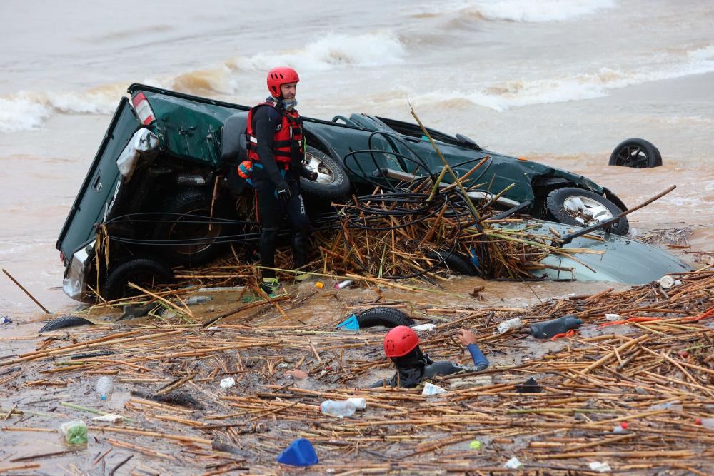 Rescuers search the waters along the beach of the popular resort of Agia Pelagia, on the southern Greek island of Crete, following flash floods on October 15, 2022. AFPPIX