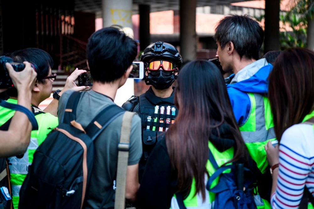 A male protester (C), who gave his age as 16, speaks to the media at the campus of the Hong Kong Polytechnic University in the Hung Hom district of Hong Kong on Nov 20. — AFP