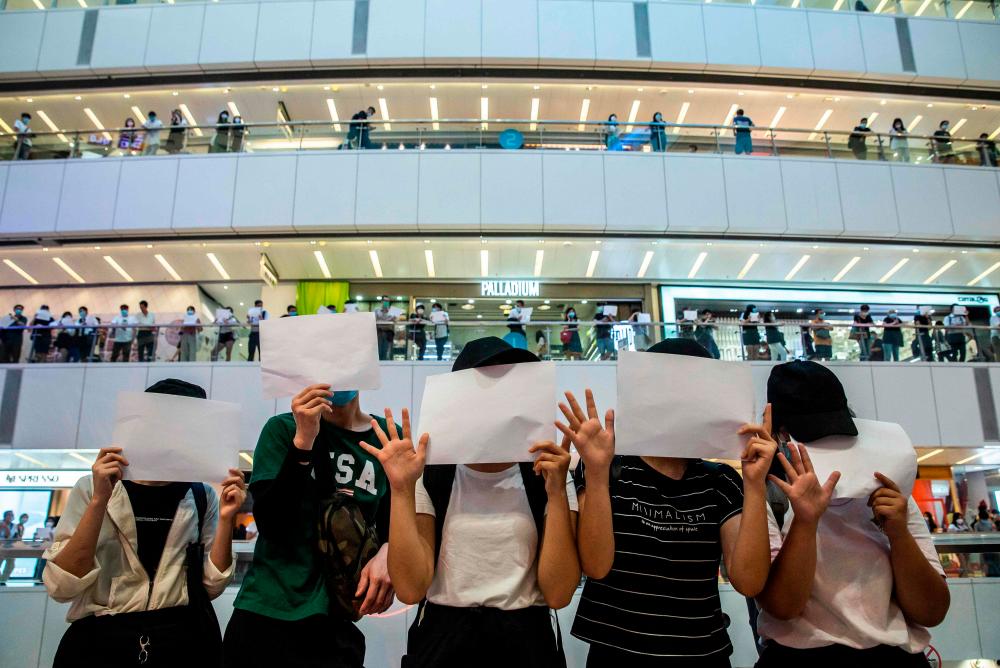 Protesters hold up blank papers during a demonstration in a mall in Hong Kong on July 6, 2020, in response to a new national security law introduced in the city which makes political views, slogans and signs advocating Hong Kong’s independence or liberation illegal. Hong Kongers are finding creative ways to voice dissent after Beijing blanketed the city in a new security law and police began making arrests for people displaying now forbidden political slogans. — AFP