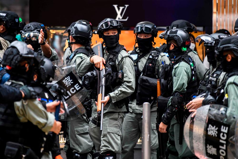 Riot police take part in a crowd dispersal operation in the Central district of Hong Kong on May 27, 2020, as the city’s legislature debates over a law that bans insulting China’s national anthem. — AFP