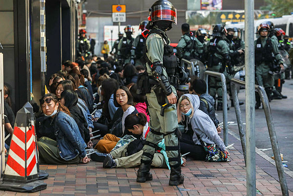People are detained by police near the Hong Kong Polytechnic University in Hung Hom district of Hong Kong on Nov 18 2019 — AFP