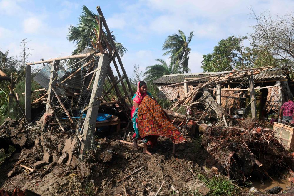 A woman cleans her house damaged by Cyclone Bulbul in Bakkhali on Nov 10, 2019. — AFP
